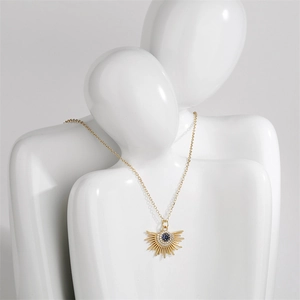 Detail of colorful zircon evil eye pendant on a golden chain shown on a white model bust