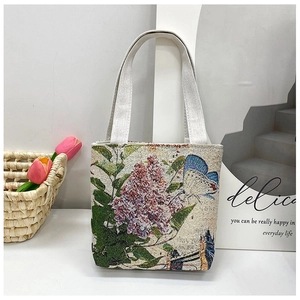 Detail of lilac and butterfly embroidery on beige canvas handbag with elegant pattern