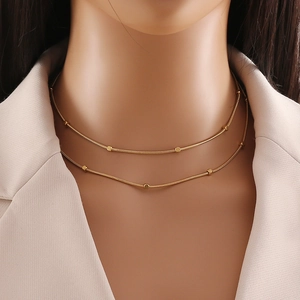 Goldene doppellagige Schlangenkette mit quadratischen Perlen an einem Modell
