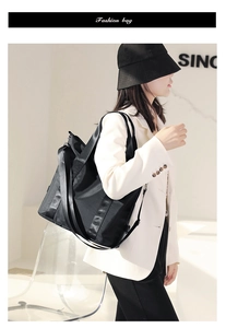 Fashionable black nylon crossbody bag styled with a white blazer for a modern casual look