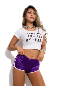 Detail of white crop top with 'SENDING YOU ALL MY HEART' text and purple satin shorts