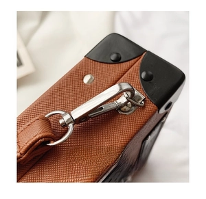 Close-up of silver hardware strap buckle and reinforced black corner on radio box bag