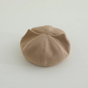 Detailed close-up of a beige vertical striped knit cat ear beret for children and toddlers