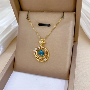 Detail of star and crescent moon necklace with blue gem in luxury jewelry box