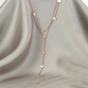 Minimalist multi-layer rose gold heart pendant necklace on a smooth silk background