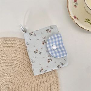 Close-up of floral corduroy coin purse with blue checkered flap and lobster clasp