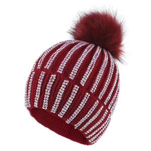 Burgundy ribbed knit beanie with sparkling rhinestones and a large faux fur pom-pom