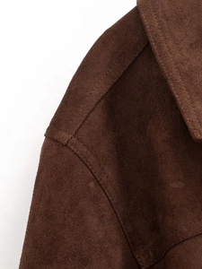 Close-up of the notch lapel and shoulder seams on a dark brown suede blazer