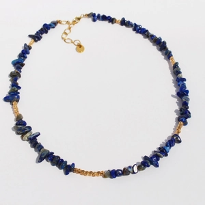 Handmade lapis lazuli and baroque pearl necklace with golden beads on white background