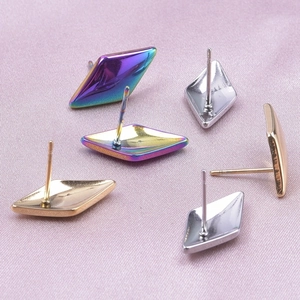 Macro view of geometric stainless steel stud earrings in rainbow, gold, and silver tones