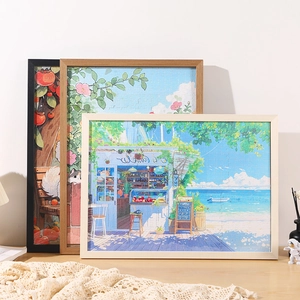 Solid wood jigsaw puzzle frames with colorful illustrations on a light wooden table