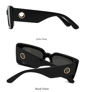 Detail view of black rectangular sunglasses featuring gold metal ring on wide temples
