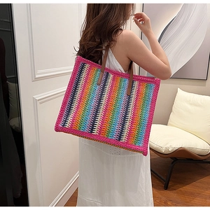 Detailed knit texture of rainbow striped tote bag with sturdy leather handles and large capacity