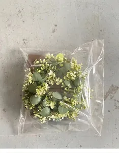Artificial green leaf wreath shown in transparent protective packaging bag for home decor