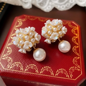 Detailed macro view of silver needle pearl earrings with resin petals and zircons