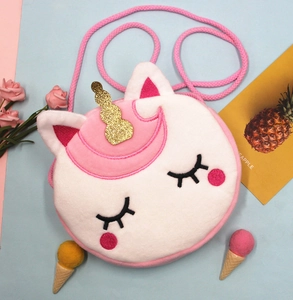 Vue détaillée du sac licorne en peluche blanche avec corne dorée et broderies fines