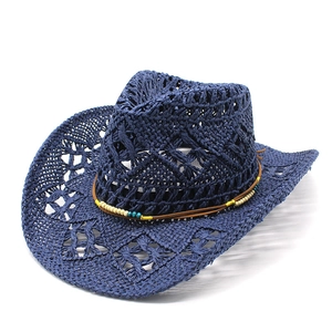 Detail of navy woven straw cowboy hat with cutout texture and ethnic beaded trim