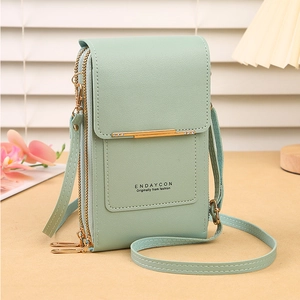 Detail of mint green crossbody phone bag with pebble leather texture and gold metal accents