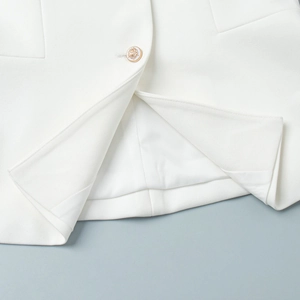 Detail of white twill fabric vest with golden crest button and smooth inner lining