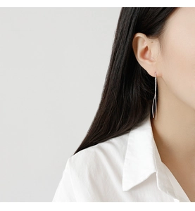 Minimalist S925 sterling silver S-shaped long threader earrings shown on a model's ear
