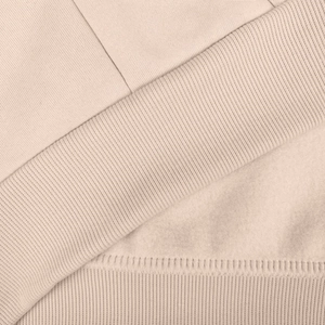 Detailed close-up of apricot thermal knit fabric with soft fleece lining and ribbed cuff