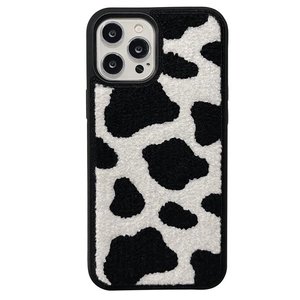 Plush cow print phone case for iPhone 16 Pro Max with soft fuzzy texture on white background