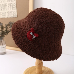 Close-up of brown plush bucket hat with red rabbit patch and checkered bow details