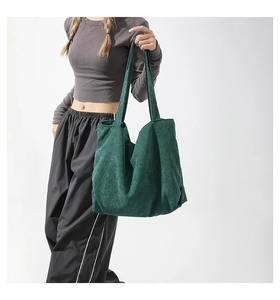 Detail of dark green corduroy tote bag showing ribbed texture and spacious shoulder design