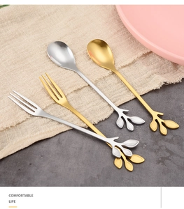 Detailed view of gold and silver stainless steel leaf-shaped spoons and dessert forks