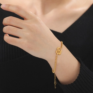 Golden stainless steel box chain bracelet with Indian Yoga Om symbol on a female wrist