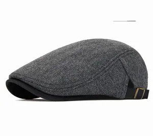 Detail of dark gray herringbone beret hat with adjustable metal buckle and strap