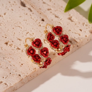 Detailed macro view of red rose earrings with gold plating and sparkling crystals