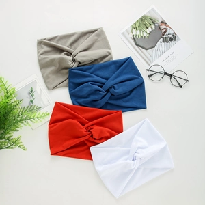 Detail of four yoga headbands in grey, blue, red, and white with a stylish twist design