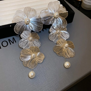Dettaglio degli orecchini a fiore in rete d'argento con perle su scatola regalo