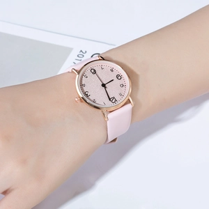 Pink leather strap watch with rose gold case on wrist, feminine glitter dial detail