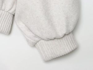 Close-up of soft light grey fleece fabric and ribbed cuffs on bomber jacket