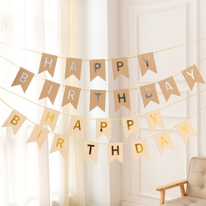Close-up of Happy Birthday kraft paper banners with gold and silver lettering decoration