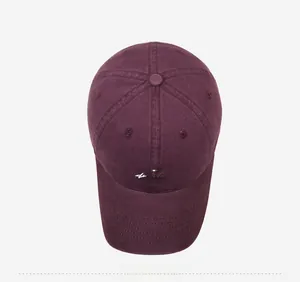 Top-down view of burgundy cotton baseball cap with white adventure embroidery detail