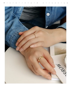 Detail of gold twisted rope and chain rings layered on model with micro-inlaid zirconium