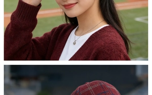Close-up of wine red plaid woolen cap with matching knit cardigan and silver necklace