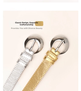 Close-up of stylish gold and silver skinny belts with large polished half-moon buckles