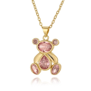 Detailed close-up of a golden teddy bear pendant featuring sparkling pink zircon stones