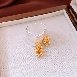 Modern 18K gold plated wide open ring featuring irregular wave edges and gold bead tassels