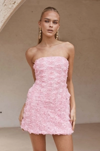Détail de la robe rose moulante avec textures de roses 3D et décolleté sans bretelles