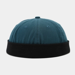 Detail of teal and black patchwork cotton docker hat showing twill texture and eyelets