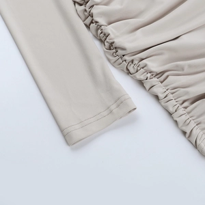 Détail de la double piqûre aux manches et des fronces latérales de la robe beige