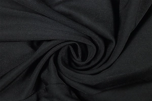 Close-up of the black ribbed fabric texture and twill weave pattern of the athletic jumpsuit