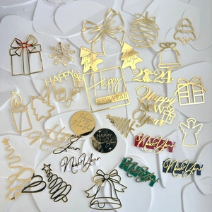 Flat lay of golden acrylic cake toppers with Happy New Year 2024 text and holiday icons