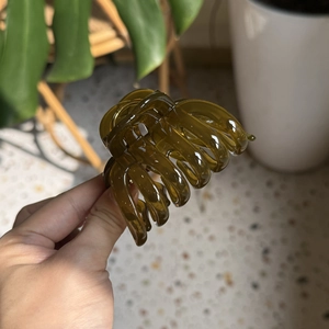 Close-up of translucent olive green pumpkin hair claw clip made of polished resin