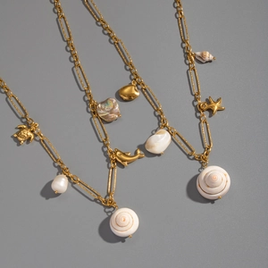 Détail de colliers en titane doré avec pendentifs tortue de mer, coquillage et étoile de mer